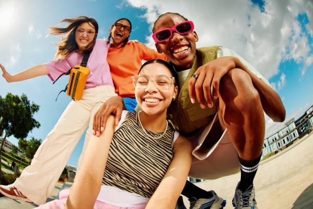 Four girls in trendy fashionable clothes posing for a picture.