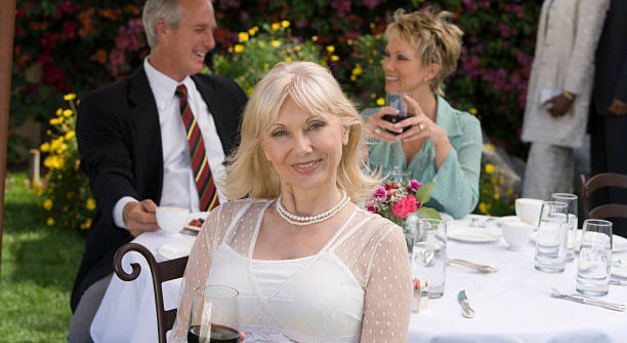 1 male and 2 female over 60 in wedding dress in wedding.