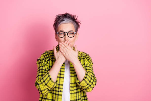 Fashionable woman over 50 in pink background.